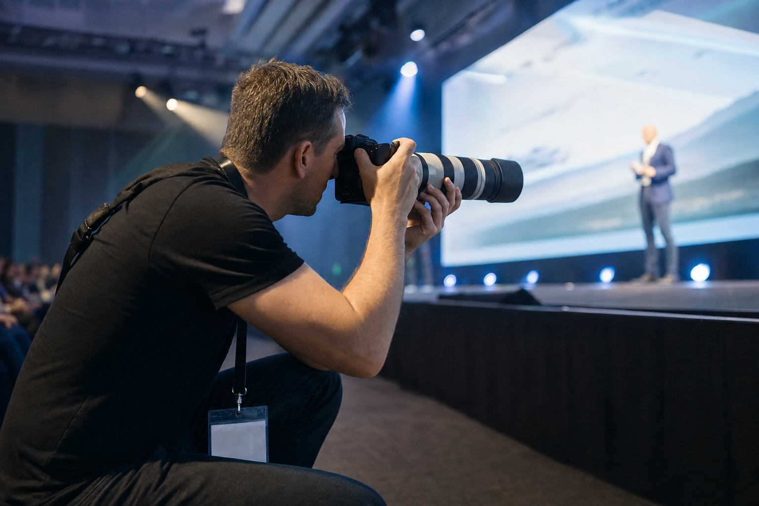 Fotografo con teleobiettivo che riprende un keynote aziendale
